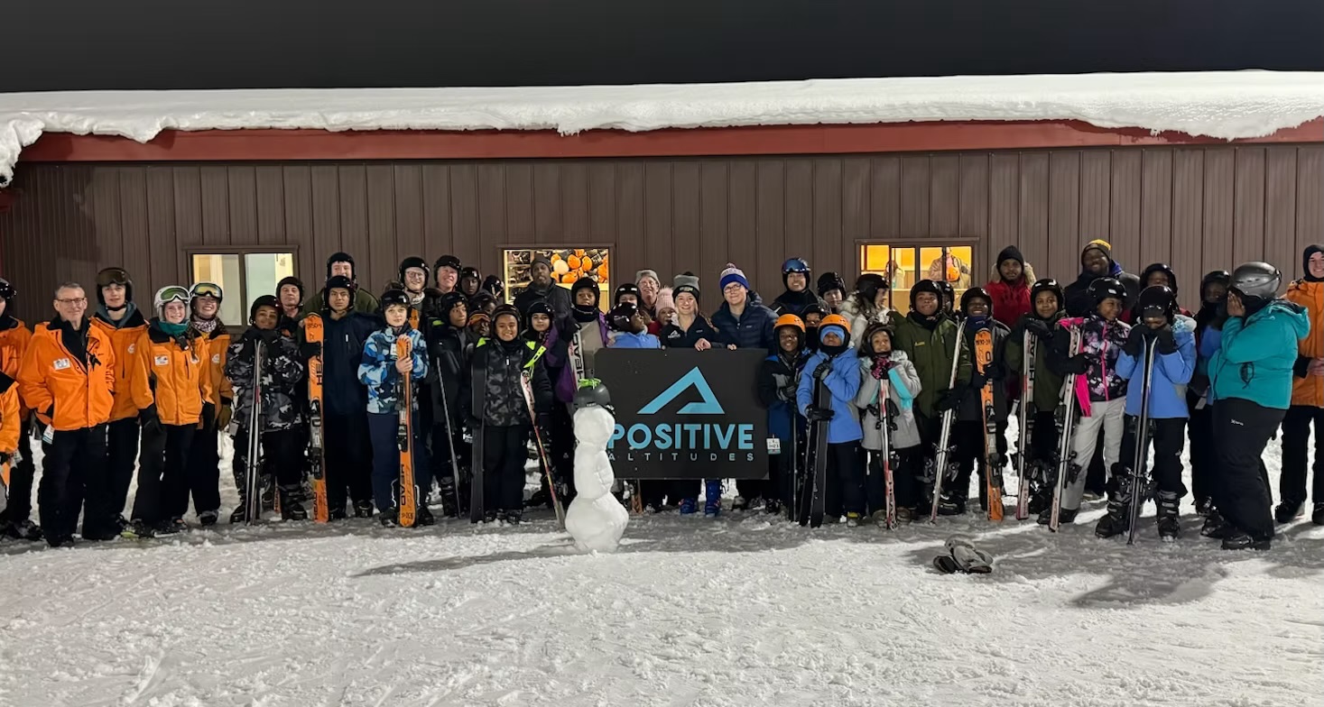 The full Positive Altitudes group and mentors at Sunburst holding their banner